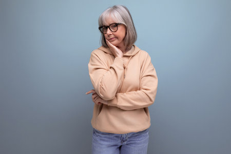 mature woman with gray hair in casual look on studio background with copy space
