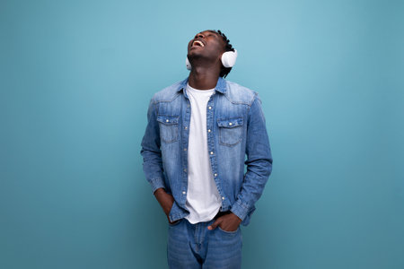 cool dude american man with dreadlocks in denim jacket listening to favorite music playlist with headphonesの写真素材