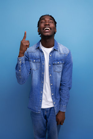 close-up portrait of a smart young stylish american guy with dreadlocks in a denim jacket with some kind of genius ideaの写真素材