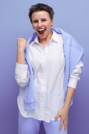 lucky happy young lady with tousled hair in a white shirt in an informal settingの写真素材