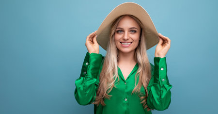stylish young woman in summer hat with brim on blue backgroundの写真素材