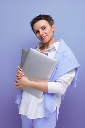 confident stylish freelancer woman with laptop mockup on studio backgroundの写真素材