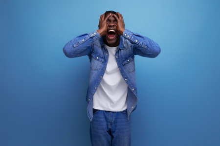 shocked happy african man with dreadlocks in denim jacket won the lottery