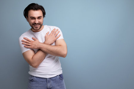 cheerful young brunette guy in a white t-shirt and jeansの写真素材