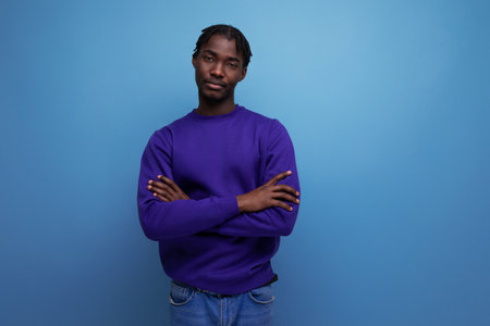 charming dark-skinned young brunette man with dreadlocks in a blue sweatshirtの写真素材