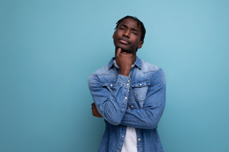 charismatic dude african man with curly hair in a denim jacket on a blue backgroundの写真素材