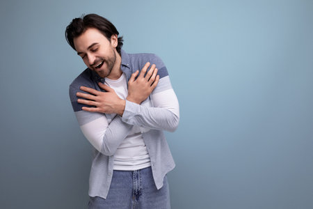 emotional young brutal brunette guy on a studio background for a posterの写真素材