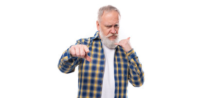 well-groomed mature gray-haired man with a beard in a shirt points his finger on a white background...