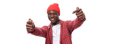 confident young ethnic african guy in stylish look pointing with index finger at promotional offer isolated on white backgroundの写真素材