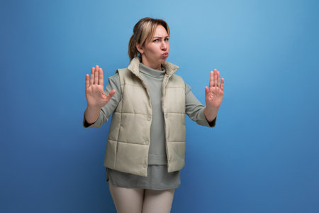 blond young woman showing refusal and disagreement gesture on studio backgroundの写真素材