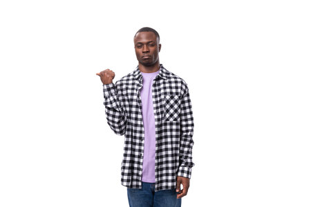stylish young american guy with short haircut dressed casually pointing with his hand on a white background with copy spaceの写真素材