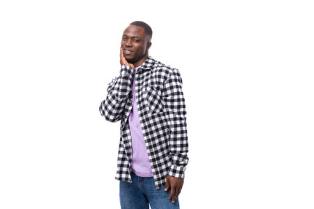portrait of a well-groomed dark-skinned man in a plaid shirt and jeans isolated on white space
