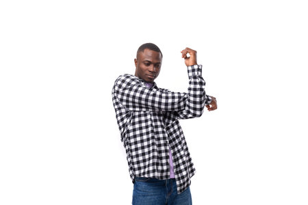 portrait of a handsome 30 year old african guy dressed in a plaid shirt dancing on the background with copy spaceの写真素材