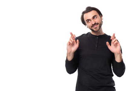 hopeful 30s authentic brunet male adult in black sweatshirt praying on white background with copy spaceの写真素材