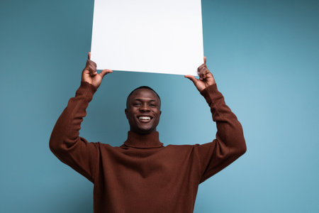successful african businessman demonstrates his projects using a white sheet of screenの写真素材