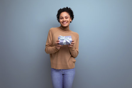 young attractive latin woman with black afro ponytail giving gift box for anniversary