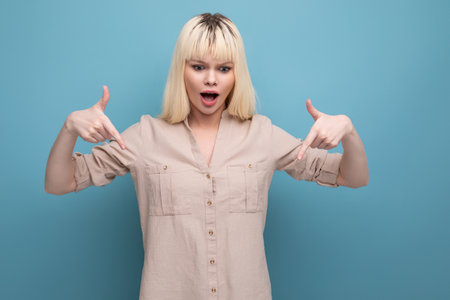 surprised blond woman in a shirt shows for having an ideaの写真素材