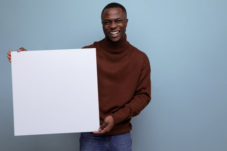 successful african businessman demonstrates his projects using a white sheet of screenの写真素材