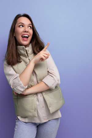 pensive black-haired young lady in casual clothes proposes an idea on studio backgroundの写真素材