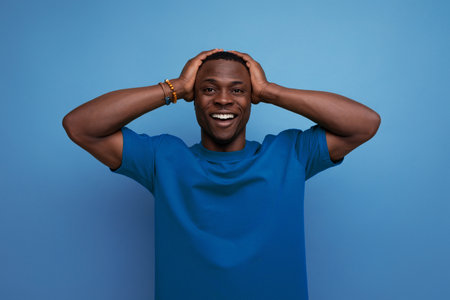 A 30 year old dark-skinned American man dressed in a basic T-shirt poses in front of copy space. lifestyle conceptの写真素材