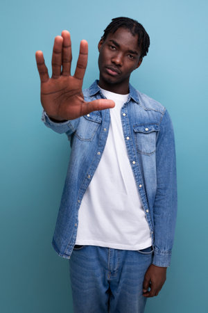 african man with dreadlocks shows stop gesture