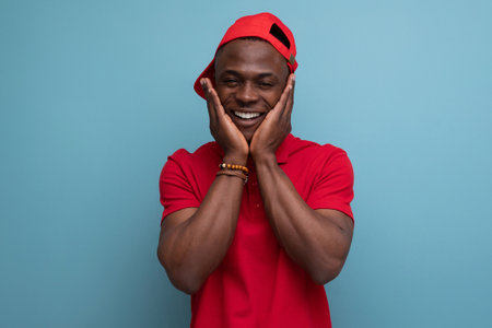 young American man dressed in corporate attire consisting of a baseball cap and a cotton T-shirtの写真素材