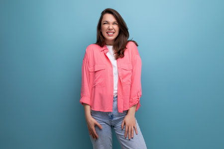 laughing brunette woman in pink shirt and jeansの写真素材