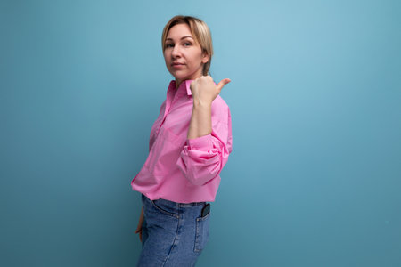 young successful European blond leader woman with ponytail dressed in a pink blouse talks about a business ideaの写真素材