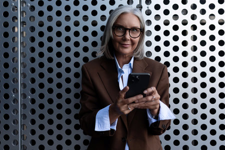 portrait of a well-groomed gray-haired middle-aged woman with a bob hairstyle dressed in a jacket and trousers. middle aged business conceptの写真素材