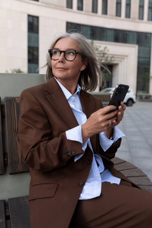 portrait of a well-groomed charming entrepreneur woman of mature years in a brown suitの写真素材