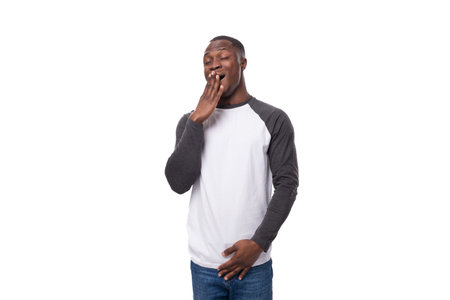 young african man with short haircut wearing a sweatshirt yawns