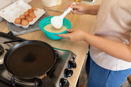 the woman spreads the batter in the panの写真素材