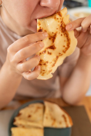 woman having breakfast with pancakes in her kitchenの写真素材