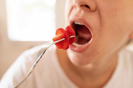 woman puts strawberry in mouth
