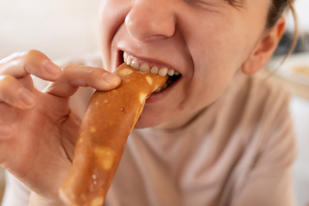 woman biting gluten-free pancakes at breakfastの写真素材