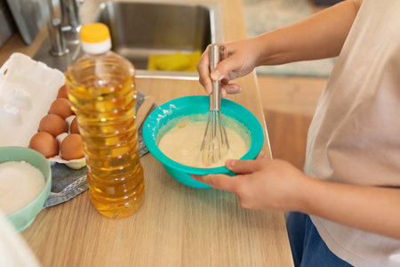 a woman makes dough using sunflower oil