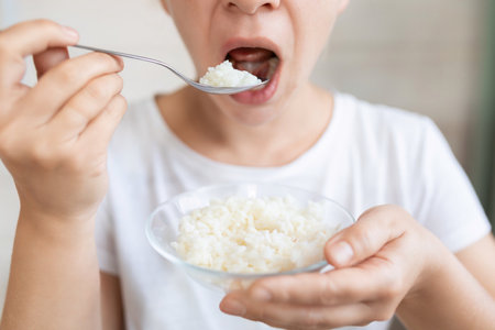 young woman eating rice while dietingの写真素材