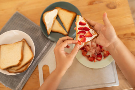 womens hands make a homemade strawberry sandwichの写真素材