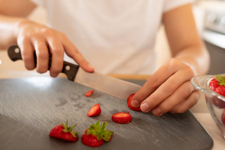 woman slicing strawberries, close-up photoの写真素材