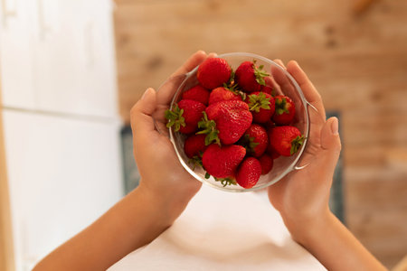 a woman holding a handful of strawberriesの写真素材