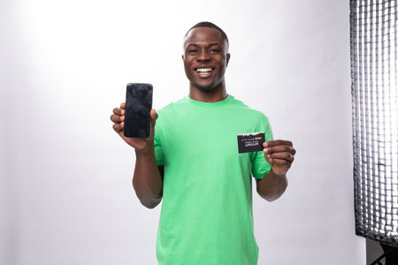 american satisfied brunette man with short haircut dressed in a light green t-shirt holds a...