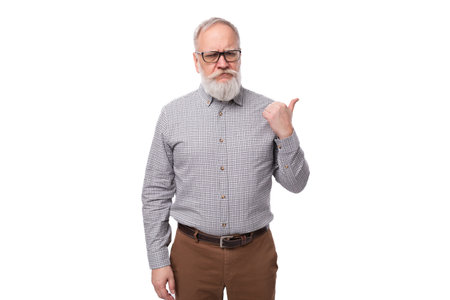 cute smart old man with a mustache and beard in glasses dressed in a shirt and trousers works in a business companyの写真素材