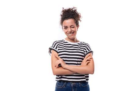 young positive curly brunette woman in a black and white striped casual t-shirtの写真素材