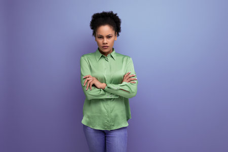 young hispanic brunette lady dressed in a green stylish shirt against the background with copy spaceの写真素材