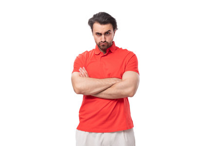 young handsome brunette man with a beard is dressed in a standard red t-shirt on a white background with copy spaceの写真素材