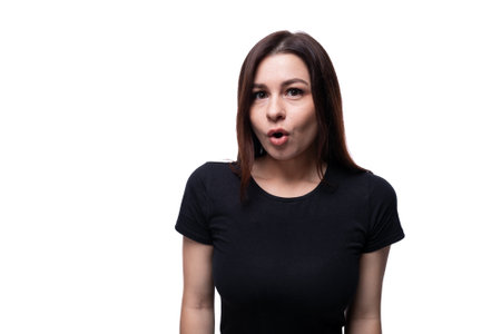 Surprised young woman in a black T-shirt looking at the camera