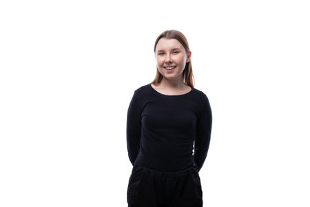 School age girl dressed in black clothes on a white backgroundの写真素材