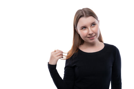 Cute school age girl dressed in black clothes on a white backgroundの写真素材
