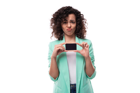 young curly brunette secretary woman in a blue jacket shows a model of a bank plastic card