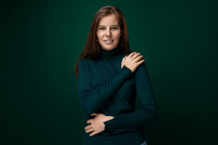 A 30-year-old slender woman with model appearance is wearing a green turtleneckの写真素材